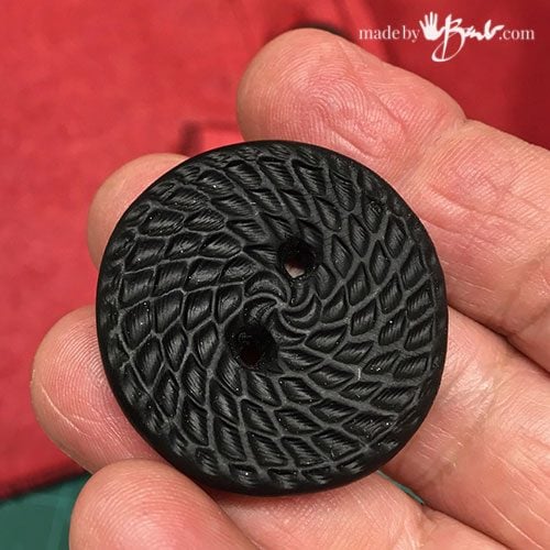 close-up of large black button made of fimo clay