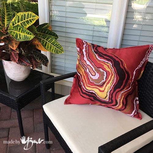 close-up of red geode design cushion on black chair